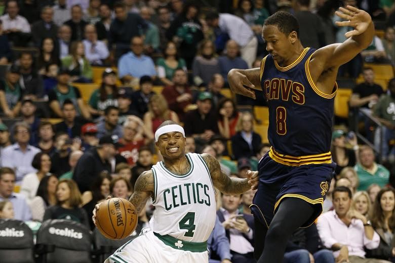 Celtics point guard Isaiah Thomas is tripped by Cavaliers forward Channing Frye during the game at TD Garden. He overcame a recent shooting slump to top score with 31 points in Boston's 103-99 victory over the holders.