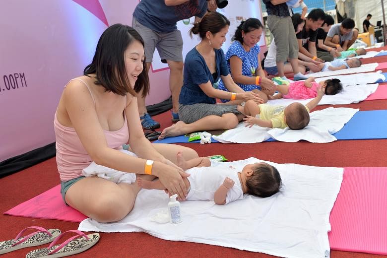 Mothers learning how to massage their babies at the inaugural Great Eastern SuperMom Carnival in 2015. While the public service's pilot scheme to offer more unpaid infant-care leave has been lauded for giving parents more time to spend with their bab
