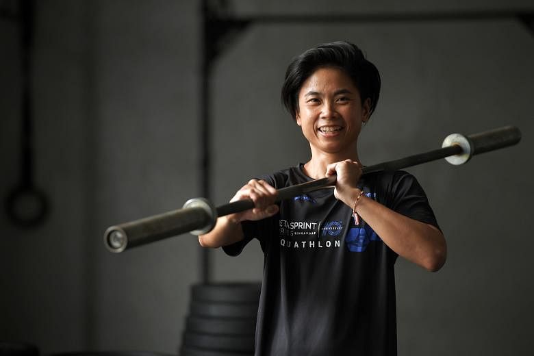 Miss Lim Soo Ee posing with a barbell in a crossfit gym. Despite running in races only around three years ago, she ran 40 races to celebrate her 40th birthday last year. She is training for her first triathlon this year.
