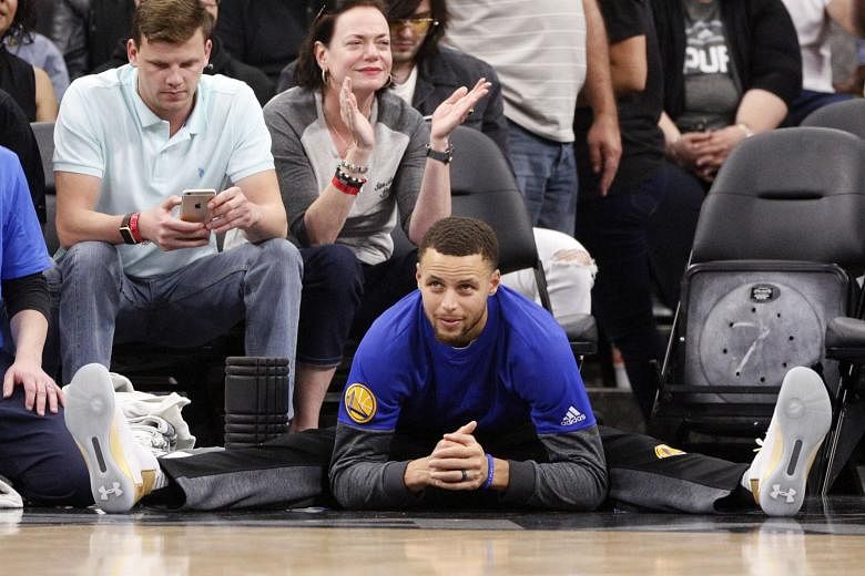 Warriors' Stephen Curry watching his team-mates take on the Spurs from the sidelines. The All-Star was rested along with other key Warriors.