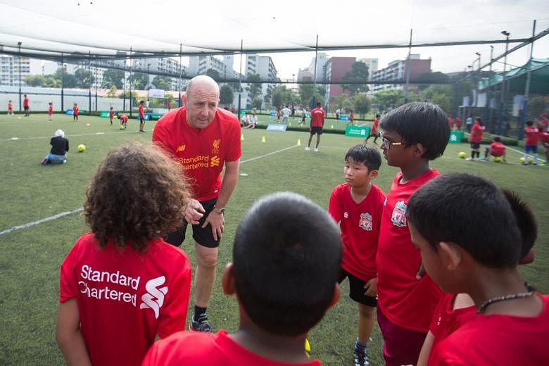 Former Liverpool star Gary McAllister shares some tricks of the trade with a group of young players at the Standard Chartered Trophy 2017 Singapore Qualifying Tournament.
