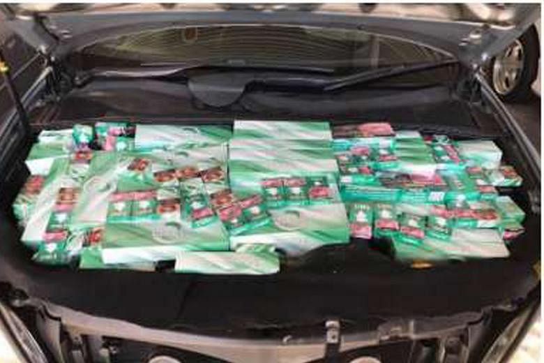 A total of 322 cartons and 879 packets of cigarettes were found hidden in the Singapore-registered car, including inside its engine compartment.