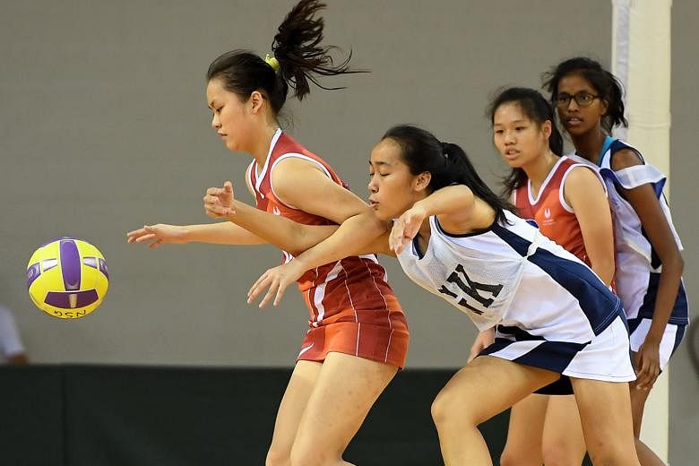 Above: CHIJ goalkeeper (in white) Tina Leong defends against SSP's goal shooter Priscilla Wong. CHIJ won the B Division final 42-18. Left: Dunman's squad celebrate winning their school's first C Div netball title in 10 years.