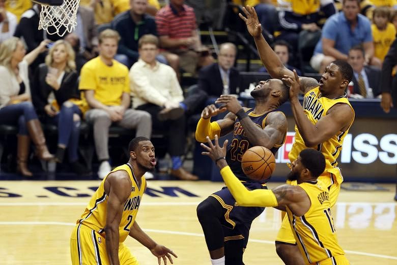 Cleveland Cavaliers forward LeBron James (23) gets fouled while going up for a shot against the Indiana Pacers' Paul George (13) and Kevin Seraphin during the reigning champions' opening-round Eastern Conference play-off series. James now has a total