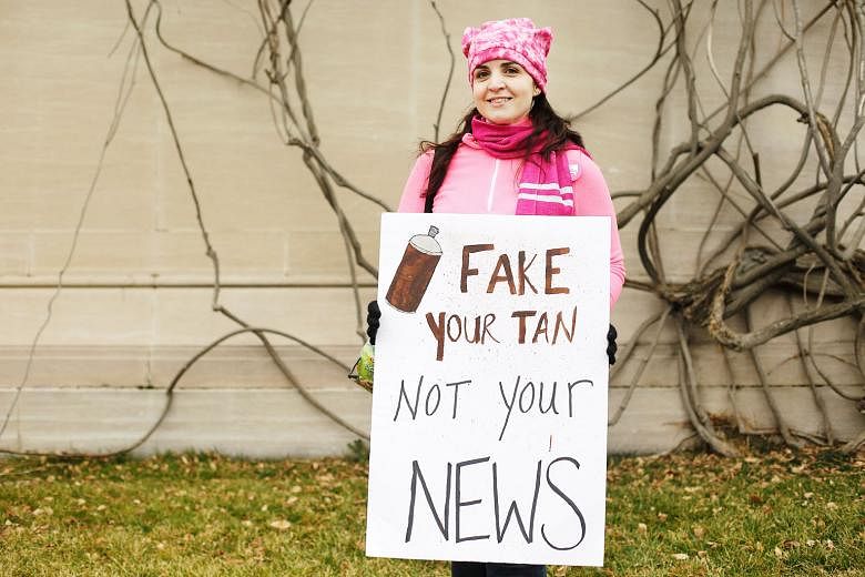A protester displaying a sign referring to fake news during a Women's March in Washington on Jan 21. A lack of understanding about the media, and being unable to identify and verify fake news have led to it spreading widely, says the writer.