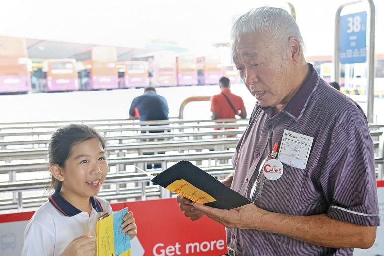 Above: Bus driver Tan Hock Kee receiving a thank-you card from a Tampines Primary School pupil. 