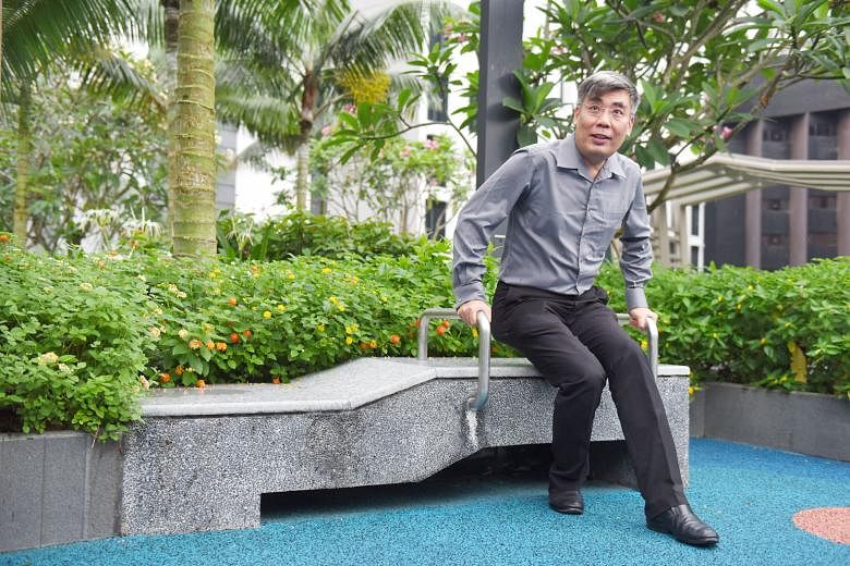 Mr Eng Tiang Wah, CapitaLand's vice-president for product development and design, showing how handrails fitted on benches at the playground (above) make it easier for the elderly to get up from their seats.