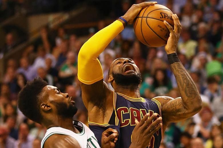 The Cavs' LeBron James drives to the basket under the challenge of the Celtics' Jaylen Brown. The Cleveland forward led all scorers with 30 points on the night, equalling Kareem Abdul-Jabbar's mark of scoring 30 or more in eight straight play-off gam