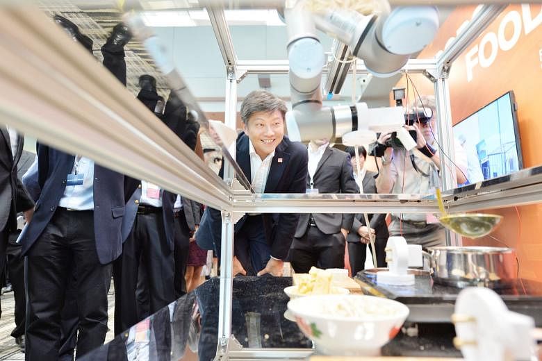 Second Minister for Transport Ng Chee Meng getting a first-hand look at robotic chef Roboto at the TechnIC@SATS exhibition. The Civil Aviation Authority of Singapore, Economic Development Board and Sats have pledged $110 million to a technology innov