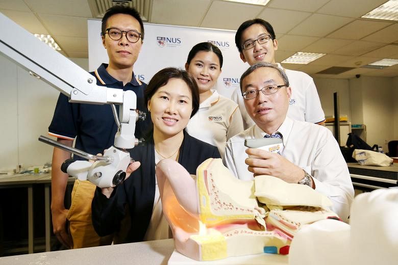 The research team behind CLiKX is made up of (from right) Dr Liang Wen Yu, Dr Lynne Lim, Ms Ng Cailin, Associate Professor Tan Kok Kiong (holding the device) and Mr Gan Chee Wee. CLiKX allows for the procedure to be done in a ward or clinic and needs