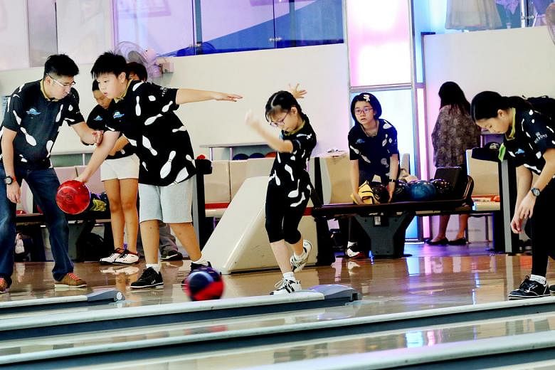 Ex-world champion bowler Remy Ong showing youngsters how to deliver the ball. He says ex-sportsmen are aware not only of the technical skills needed to succeed but also the mental strength required.