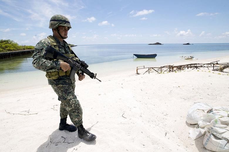 A Filipino soldier patrolling Pagasa island in the South China Sea. China has overlapping claims to territories in the waterway with Asean member states Brunei, Malaysia, the Philippines and Vietnam, as well as Taiwan.