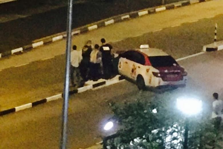 Passers-by helping to move a cab that was stuck on a road divider in Choa Chu Kang Avenue 5 last Friday night. The taxi was successfully moved only after about 10 people gathered to help.