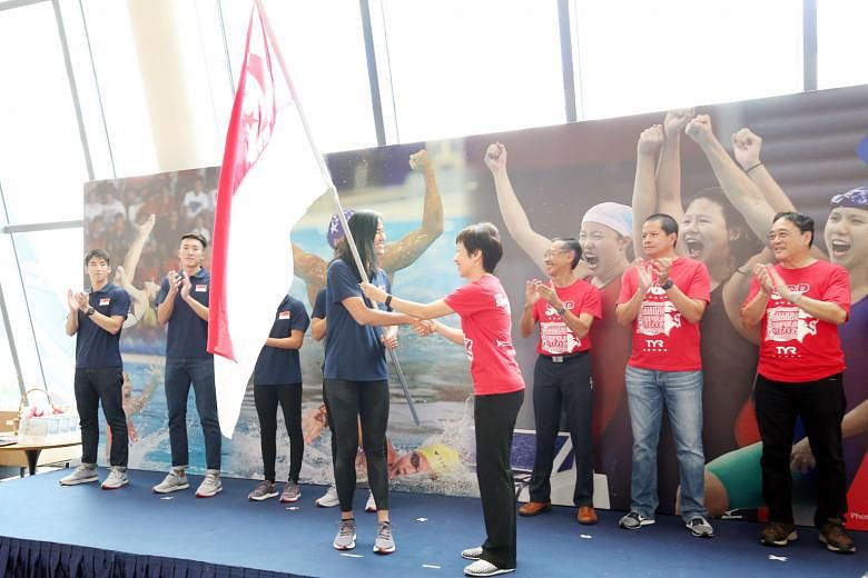 National swimmer Quah Ting Wen receiving the Singapore flag from Minister for Culture, Community and Youth Grace Fu for the 29th SEA Games, which will be held in KL.
