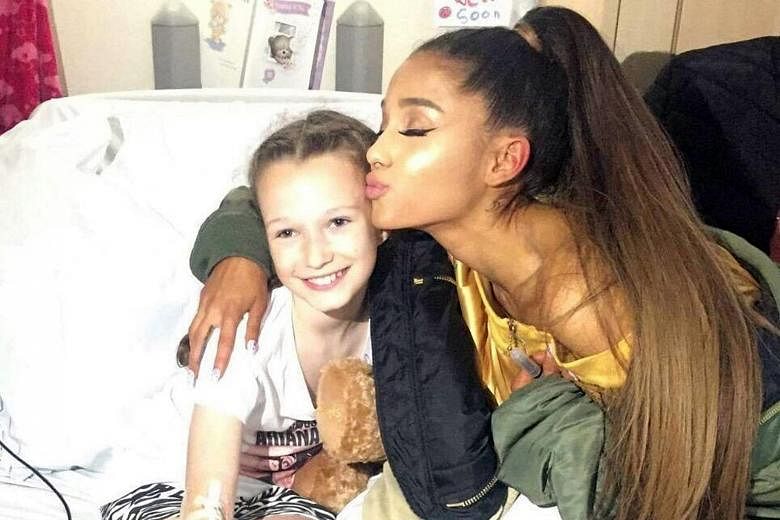 Singer Ariana Grande visiting a young fan injured in the bomb attack. She brought presents and posed with the injured fans for wefies.