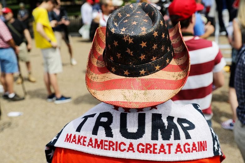 A demonstrator at a rally in front of the White House last Saturday to show support for President Donald Trump's decision to withdraw from the Paris climate accord. Mr Trump's "America First" policy has been called "Made in America 1955" by critics s