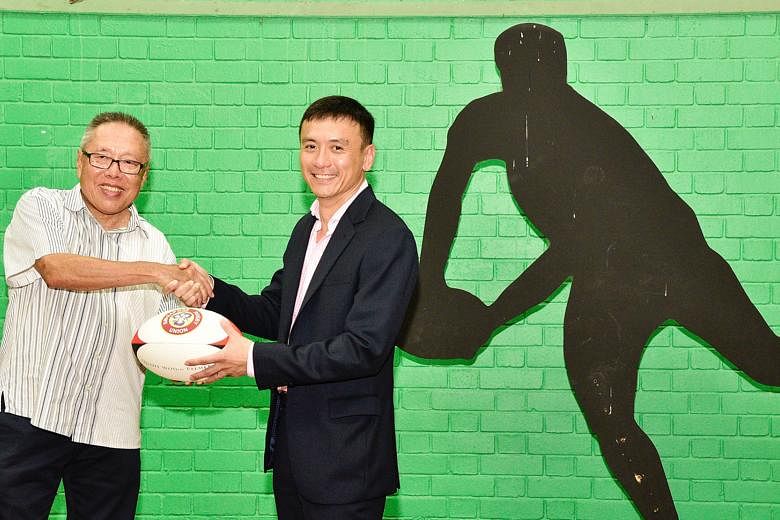 Low Teo Ping, (left) the outgoing president of the Singapore Rugby Union, shaking hands with his successor Terence Khoo, whose aim is to attract more people to the sport.
