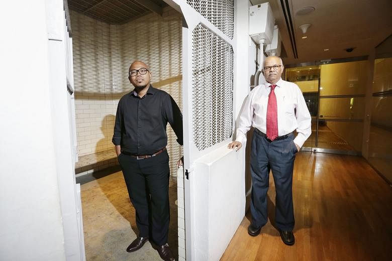 Supreme Court staff Muhd Hakim, 39, (far left) and S. Kathiarasan, 69, at one of the two holding cells that have been preserved. The other cells and passageways have been turned into office space for National Gallery staff. 