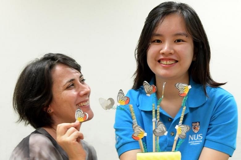 NUS PhD student Jocelyn Wee and her supervisor Antonia Monteiro with the butterfly models she used during the study. Ms Wee found that red appeared to be more effective than yellow in keeping predators at bay.