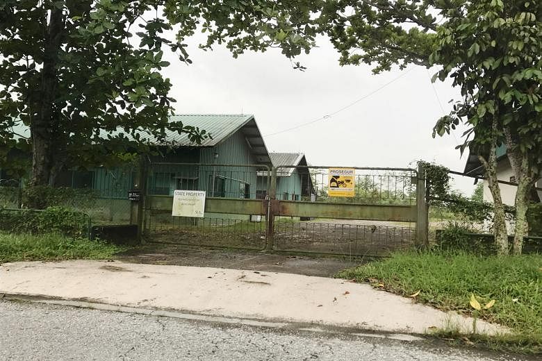 An SLA signboard hanging on the gates of a farm in Lim Chu Kang, stating that the land is now state property. The farm's licence was terminated in July 2015 for unauthorised earthworks.
