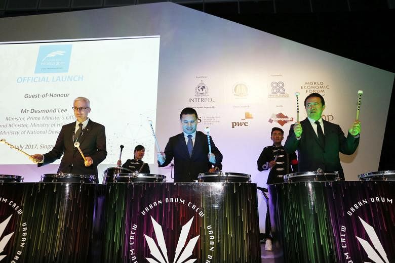 Second Minister for Home Affairs Desmond Lee (centre) playing the drums with Interpol secretary- general Jurgen Stock (left) and Interpol president Meng Hongwei at the opening of Interpol World 2017 yesterday.