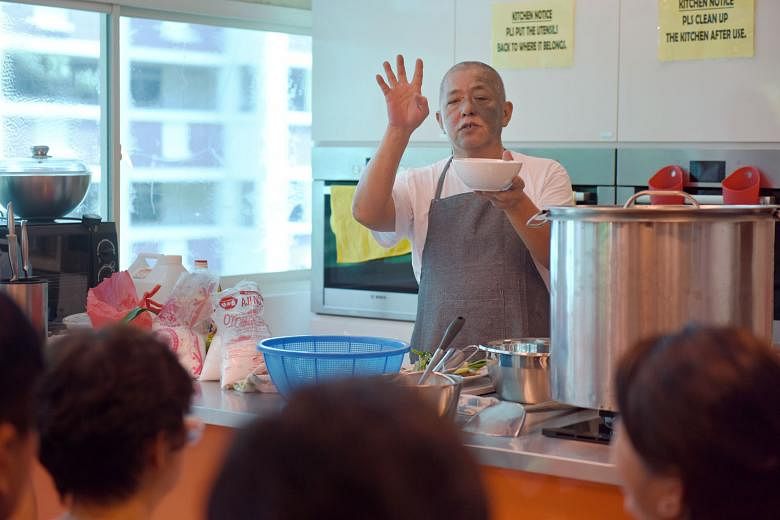 Veteran chicken rice hawker Neo Cheng Leong, 57, imparting his cooking skills during a Hawker Fare Series class on May 29. The programme - where people can pick up skills from experienced hawkers - has been "overwhelmingly subscribed" since its launc