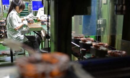Employees working on a refrigerator compressor production line at the Panasonic factory in Bedok South. Singapore's industrial output gained 2.7 per cent last month over the same period last year, mainly boosted by the transport engineering and gener