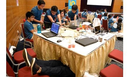 (From left) Hwa Chong Institution students Ian Wong (legs showing), Danyon Low, Denis Lan, Gaw Ban Siang, Brandon Hoong and Joel Lim. Ian Wong dived under his team's workbench for a short nap during The Straits Times National Youth Media Competition,