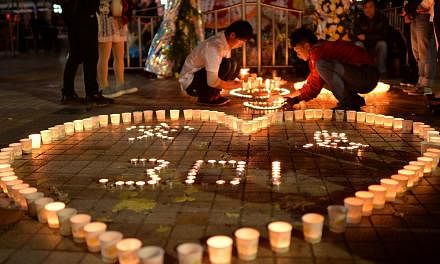 This picture taken on March 2, 2014 shows Chinese mourners lighting candles at the scene of the terror attack at the main train station in Kunming, south-west China's Yunnan province. Residents in several major cities across China have been unnerved 