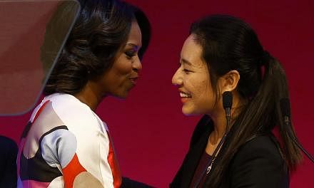 US first lady Michelle Obama (L) is greeted by student Zhu Xuanhao before giving a speech at the Peking University in Beijing on March 22, 2014. -- PHOTO: REUTERS