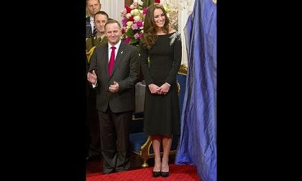 Catherine, the Duchess of Cambridge, with New Zealand Prime Minister John Key during the unveiling of a portrait of Queen Elizabeth II by New Zealand artist Nick Cuthell during a state reception at Government House in Wellington on April 10, 2014. --