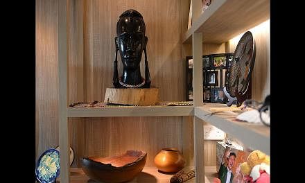 Clean lines (right) and a woody palette (far right) give the flat of Ms Catherine Cheung and Mr Elvin Too (both above) an earthy touch. Sliding panels (left) let the home owners open or close off this nook when necessary. Souvenirs from their travels