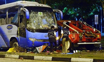 Police officers examining the wrecked private bus at the aftermath of the Little India riot in the early hours on 9 December 2013.&nbsp;The Committee of Inquiry (COI) into last December's riot in Little India found that several misunderstandings abou
