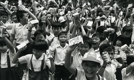 Children receive packets of milk as part of the annual Milk Day on Nov 19, 1985. -- PHOTO: ST FILE