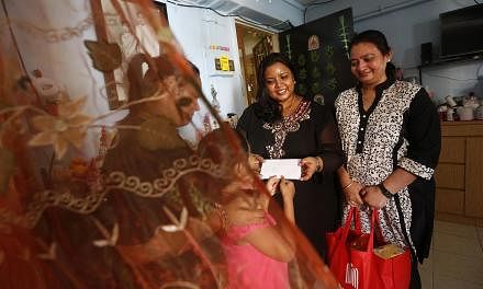 Volunteers (from right) J. Rubyrani and Sakuntala Jackson handing a letter from an inmate to his wife, Madam Eswari Vadivel, and daughter, together with a food hamper. The Angel Tree Project has had letters hand-delivered to inmates' families in the 