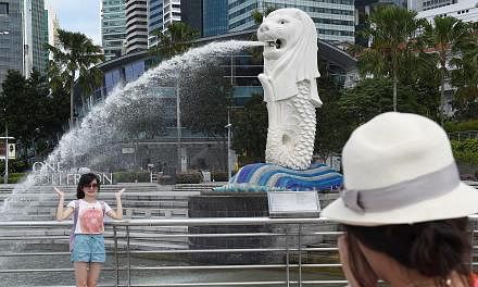 Tourists taking photos next to the Merlion on June 16, 2014. -- PHOTO: ST FILE