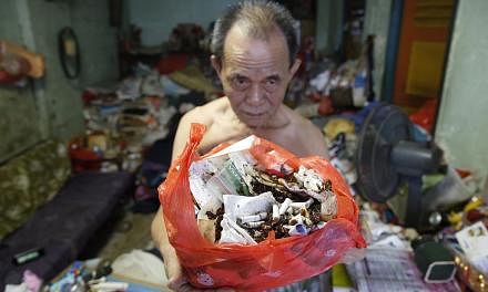 Mr Lim Chin Ting, 74, with a bag of cockroach remains and rubbish from his Eunos Crescent flat. His wife, Madam Soh Siew Zhen, has a compulsive hoarding habit, leading to a cluttered flat overrun by cockroaches and flies.