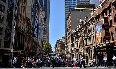 Pedestrians crossing a road in the Sydney CBD on March 3, 2015. Australia's central bank cut its cash rate a quarter point to an all-time low of 2.0 per cent on Tuesday, aiming to spur a sluggish domestic economy while keeping downward pressure on th