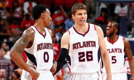 Kyle Korver (centre) of the Atlanta Hawks converses with Jeff Teague (left) during Game Two of the Eastern Conference Semifinals against the Washington Wizards at the Philips Arena, Atlanta, Georgia, on May 5, 2015. -- PHOTO: AFP &nbsp;