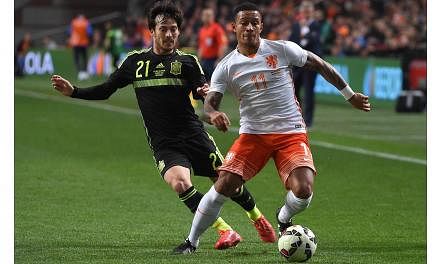 Memphis Depay (right) vies with Spain's David Silva during the friendly football match Netherlands vs Spain in Amsterdam, on March 31, 2015. -- PHOTO: AFP &nbsp;