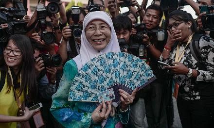 Parti Keadilan Rakyat (PKR) president&nbsp;Wan Azizah Wan Ismail&nbsp;(centre), wife of Malaysian opposition leader Anwar Ibrahim, arrives at a polling station during a by-election in Permatang Pauh, in the northern Malaysian state of Penang on March