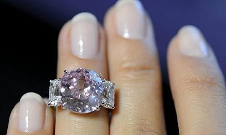A Sotheby's employee showing the "Historic Pink", a ring with a vivid pink diamond weighing 8.72 carats and with a classic non-modified cushion cut, during a preview at Sotheby's in Geneva, Switzerland on May 6, 2015. -- PHOTO: EPA