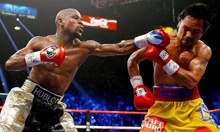 Floyd Mayweather Jr throws a left at Manny Pacquiao during their welterweight bout on May 2, 2015 in Las Vegas, Nevada. &nbsp;The “Fight of the Century” between boxing greats Floyd Mayweather Jr and Manny Pacquiao generated record pay-per-view re