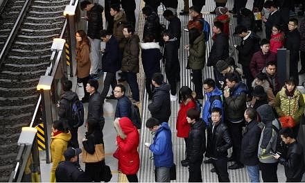 Passengers waiting for a train in Beijing on Feb 25, 2015. Beijing police are patrolling the city's subways and trains to stop people wearing face masks, strange costumes and forming flash mobs, warning commuters that such actions could jeopardise pu