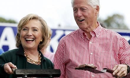 Former US Secretary of State Hillary Clinton and her husband former US President Bill Clinton holding up some steaks at the 37th Harkin Steak Fry in Indianola, Iowa, in this Sept 14, 2014 file photo. The Clintons earned at least US$30 million (S$40 m