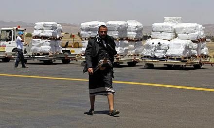 A Yemeni walks in front of emergency aid supplied by the United Nations High Commission for Refugees after it was unloaded at Sana’a International Airport, in Sana’a, Yemen, on May 16, 2015. -- PHOTO: EPA
