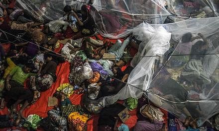 Rohingya migrants sleeping at the new confinement area in the fishing town of Kuala Langsa in Aceh province on May 16, 2015 where hundreds of migrants from Myanmar and Bangladesh mostly Rohingyas are taking shelter after they were rescued by Indonesi