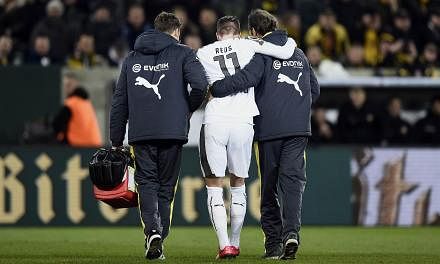 Dortmund's striker Marco Reus (centre) is helped to leave the pitch after being injured during the German Football Cup DFB Pokal round of 16 game between Dynamo Dresden and Borussia Dortmund on March 3, 2015 in Dresden, eastern Germany. -- PHOTO: AFP
