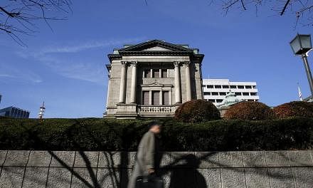The Bank of Japan maintained its massive monetary stimulus on Friday and offered a slightly more upbeat view of the economy, unfazed by first-quarter GDP data that offered mixed signs on the strength of the recovery. -- PHOTO: BLOOMBERG