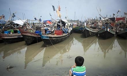 An ethnic Rohingya Muslim child looks at boats near a jetty at a refugee camp outside the city of Sittwe in Myanmar's Rakhine state on May 22, 2015. -- PHOTO: AFP